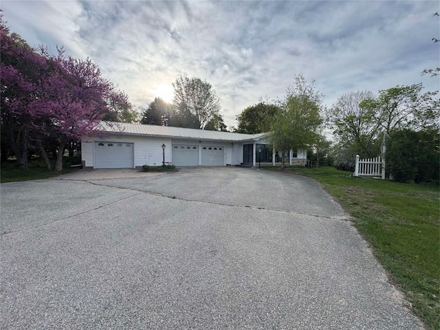 1852 215th St, Manchester, IA 52057 - ranch-style house featuring an attached garage, a metal roof, and asphalt driveway