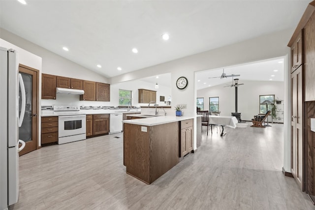 2089 117th Ct, Kalona, IA 52247 - kitchen featuring white appliances, lofted ceiling, under cabinet range hood, light countertops, and recessed lighting