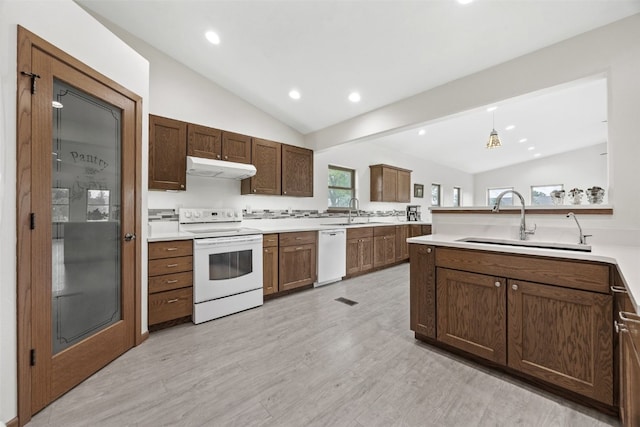 2089 117th Ct, Kalona, IA 52247 - kitchen with white appliances, vaulted ceiling, under cabinet range hood, light countertops, and light wood-type flooring