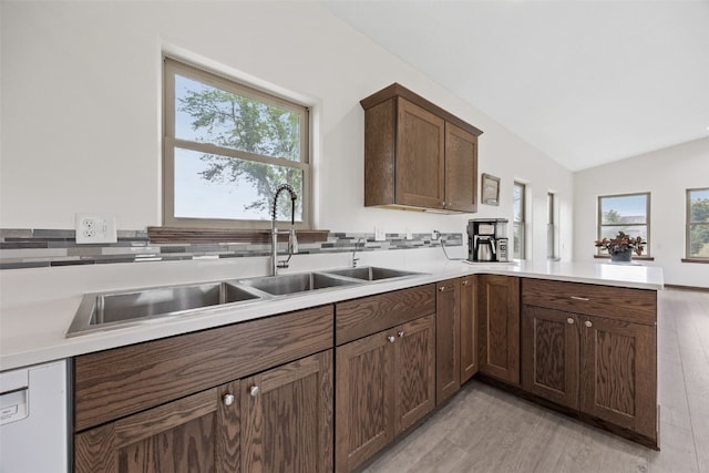 2089 117th Ct, Kalona, IA 52247 - kitchen with light wood-type flooring, healthy amount of natural light, a peninsula, light countertops, and vaulted ceiling