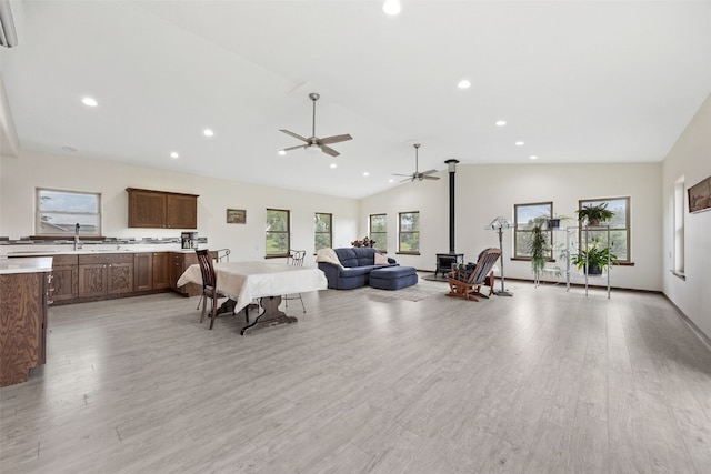 2089 117th Ct, Kalona, IA 52247 - living area featuring ceiling fan, a wood stove, lofted ceiling, recessed lighting, and light wood-style floors