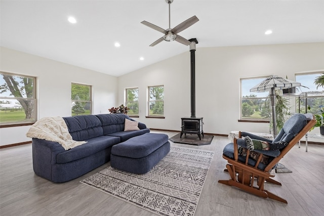 2089 117th Ct, Kalona, IA 52247 - living room featuring a wood stove, light wood-style flooring, ceiling fan, recessed lighting, and vaulted ceiling
