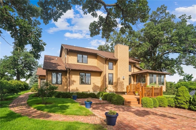 5524 Cimarron Ct, Marion, IA 52302 - view of front of property with a sunroom, a chimney, a wooden deck, a front lawn, and a patio