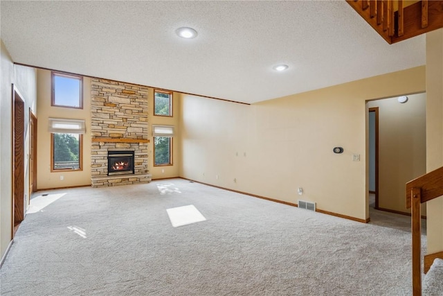 5524 Cimarron Ct, Marion, IA 52302 - unfurnished living room with carpet flooring, a stone fireplace, and a textured ceiling