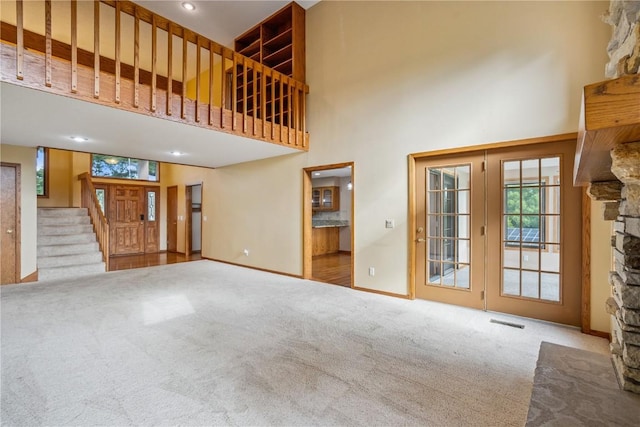 5524 Cimarron Ct, Marion, IA 52302 - unfurnished living room with a towering ceiling, carpet flooring, stairway, and a fireplace