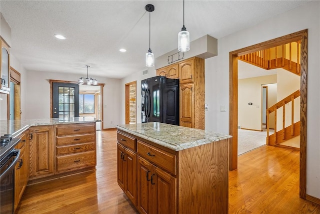 5524 Cimarron Ct, Marion, IA 52302 - kitchen featuring black fridge with ice dispenser, light wood finished floors, recessed lighting, and light stone countertops