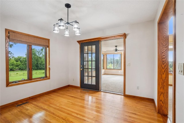 5524 Cimarron Ct, Marion, IA 52302 - empty room with light wood-style floors and a chandelier