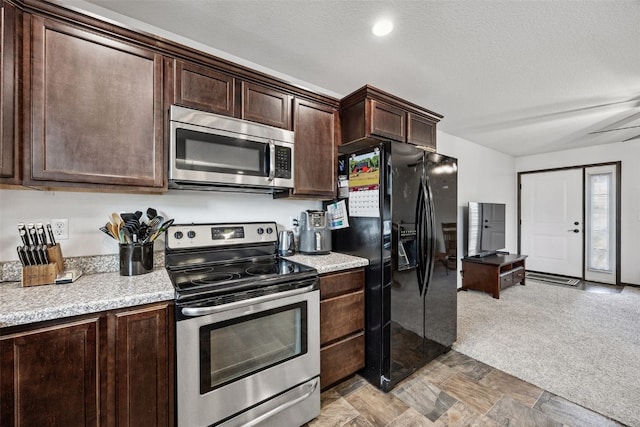 121 Woodstone Ln SW, Cedar Rapids, IA 52404 - kitchen featuring stainless steel appliances, dark brown cabinetry, light colored carpet, and a textured ceiling