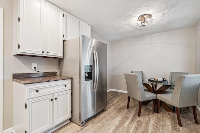 6808 Kelburn Ln NE, Cedar Rapids, IA 52402 - kitchen with stainless steel fridge, light wood finished floors, white cabinets, and a textured ceiling