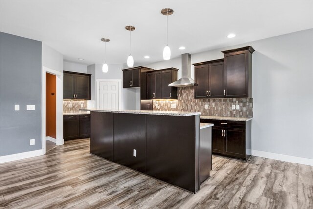 4310 Carpenter Rd NE, Cedar Rapids, IA 52411 - kitchen with wall chimney exhaust hood, light wood-style floors, dark brown cabinets, tasteful backsplash, and recessed lighting