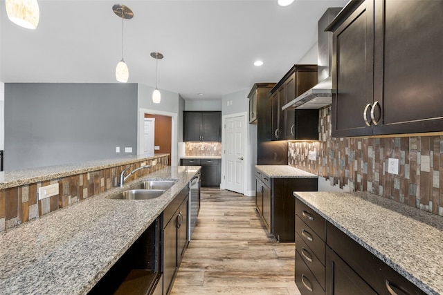 4310 Carpenter Rd NE, Cedar Rapids, IA 52411 - kitchen featuring wall chimney range hood, light stone counters, light wood-type flooring, decorative backsplash, and recessed lighting