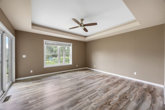 4310 Carpenter Rd NE, Cedar Rapids, IA 52411 - unfurnished room featuring a tray ceiling, a ceiling fan, and light wood-style floors