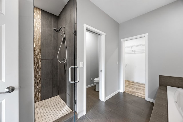 4310 Carpenter Rd NE, Cedar Rapids, IA 52411 - bathroom with a stall shower, a walk in closet, and wood finished floors
