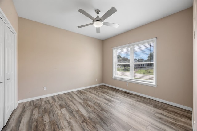 4310 Carpenter Rd NE, Cedar Rapids, IA 52411 - unfurnished bedroom with a closet, wood finished floors, and a ceiling fan