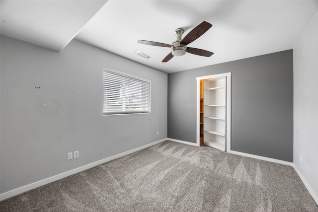 4310 Carpenter Rd NE, Cedar Rapids, IA 52411 - unfurnished bedroom with carpet floors, a ceiling fan, and a walk in closet
