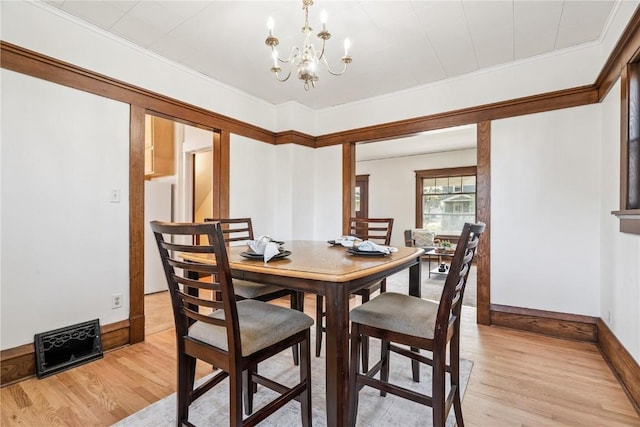395 18th St SE, Cedar Rapids, IA 52403 - dining space featuring light wood-style flooring, a chandelier, and crown molding