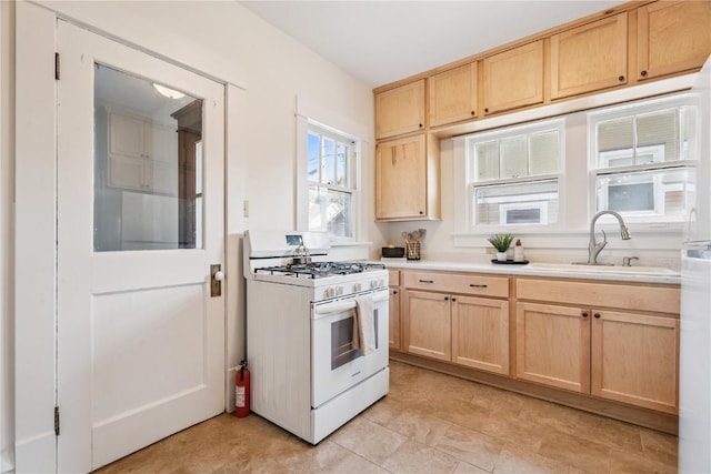 395 18th St SE, Cedar Rapids, IA 52403 - kitchen with white gas stove, light brown cabinets, and light countertops