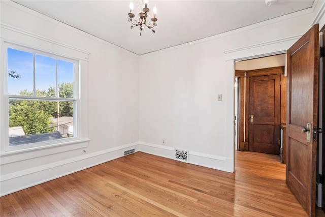 395 18th St SE, Cedar Rapids, IA 52403 - unfurnished room with a chandelier, light wood-style flooring, and ornamental molding