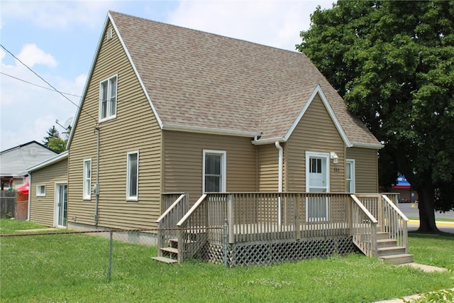 302 S Main St, Monticello, IA 52310 - back of property with roof with shingles, a lawn, and a deck