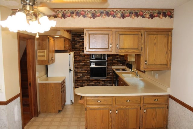 302 S Main St, Monticello, IA 52310 - kitchen featuring oven, built in microwave, light countertops, and a peninsula