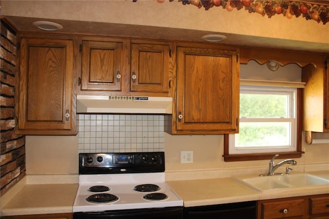 302 S Main St, Monticello, IA 52310 - kitchen with white electric stove, under cabinet range hood, brown cabinets, and light countertops