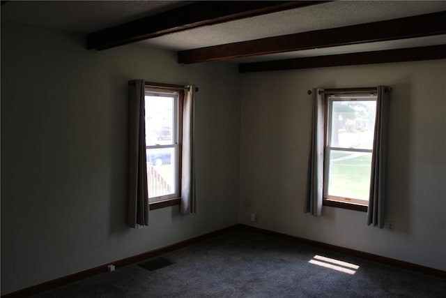 302 S Main St, Monticello, IA 52310 - unfurnished room featuring beamed ceiling, healthy amount of natural light, and dark carpet