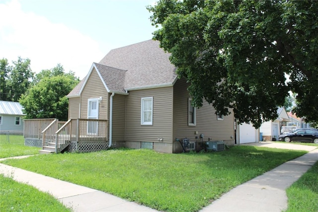 302 S Main St, Monticello, IA 52310 - view of front of property featuring a garage, a front yard, a wooden deck, and roof with shingles