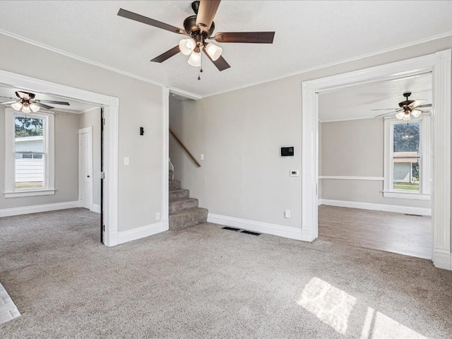 226 2nd Ave E, Lisbon, IA 52253 - unfurnished living room with carpet floors, ornamental molding, stairway, and a ceiling fan