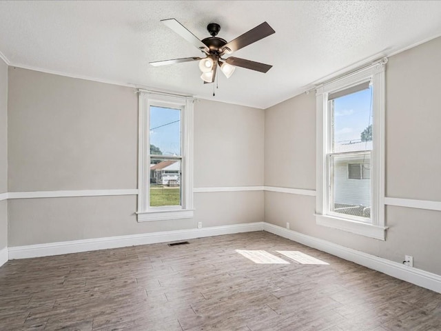 226 2nd Ave E, Lisbon, IA 52253 - unfurnished room featuring plenty of natural light, wood finished floors, a textured ceiling, a ceiling fan, and ornamental molding