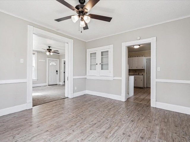 226 2nd Ave E, Lisbon, IA 52253 - empty room with wood finished floors, a ceiling fan, and ornamental molding