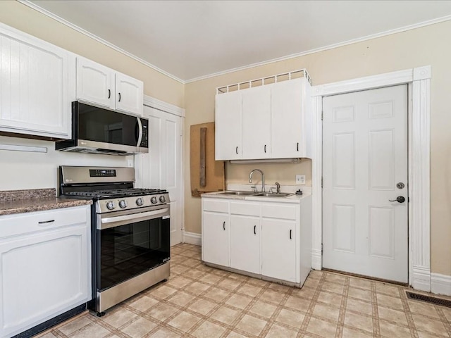 226 2nd Ave E, Lisbon, IA 52253 - kitchen with stainless steel appliances, light floors, white cabinetry, and ornamental molding