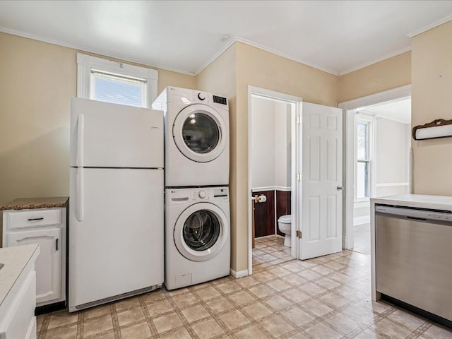 226 2nd Ave E, Lisbon, IA 52253 - washroom featuring stacked washer and clothes dryer, light flooring, and ornamental molding