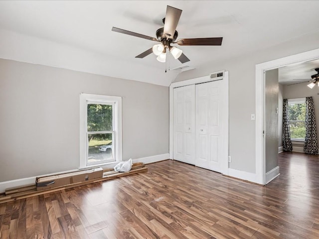 226 2nd Ave E, Lisbon, IA 52253 - unfurnished bedroom with multiple windows, wood finished floors, a closet, and lofted ceiling