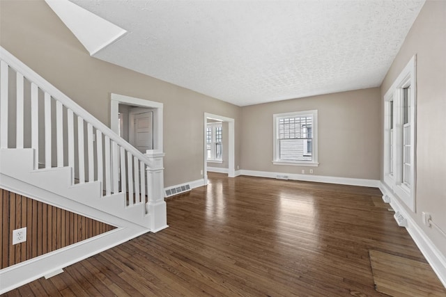 351 19th St SE, Cedar Rapids, IA 52403 - unfurnished living room featuring wood finished floors, stairs, and a textured ceiling