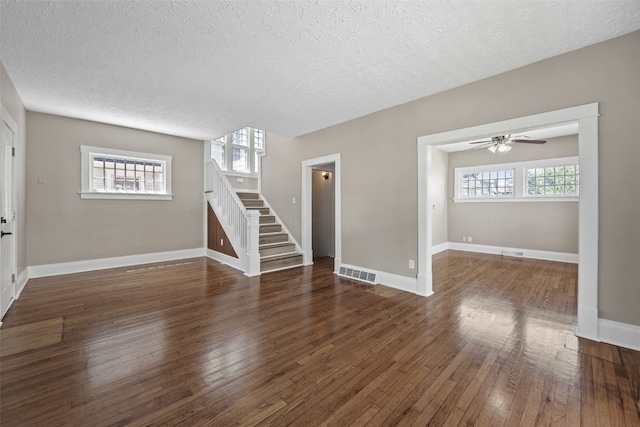 351 19th St SE, Cedar Rapids, IA 52403 - unfurnished living room with stairs, a textured ceiling, hardwood / wood-style floors, and a ceiling fan