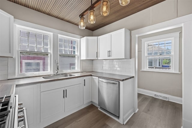 351 19th St SE, Cedar Rapids, IA 52403 - kitchen featuring appliances with stainless steel finishes, dark wood-style floors, white cabinetry, and decorative backsplash