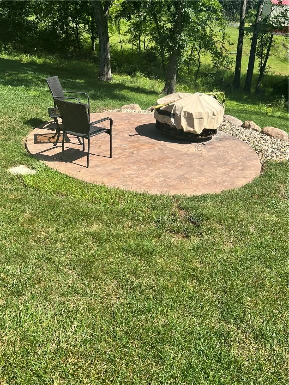 101 Canyon Rd, Montezuma, IA 50171 - view of green lawn with a fire pit and a patio area