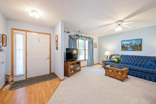 1827 Hamer Dr NW, Cedar Rapids, IA 52405 - living room featuring a textured ceiling, ceiling fan, carpet flooring, and wood finished floors