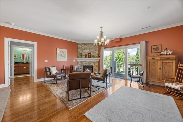 1138 Swisher St, Iowa City, IA 52245 - living room featuring ornamental molding, wood finished floors, a chandelier, and a fireplace