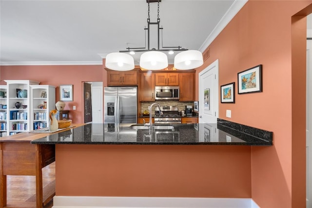 1138 Swisher St, Iowa City, IA 52245 - kitchen featuring stainless steel appliances, brown cabinetry, a peninsula, dark stone counters, and crown molding