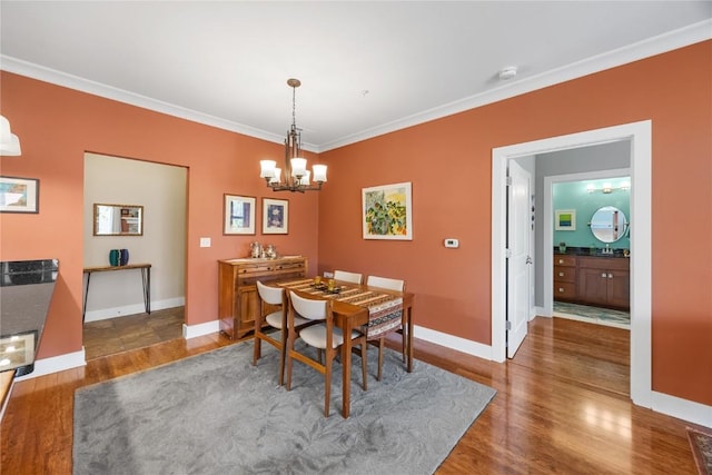 1138 Swisher St, Iowa City, IA 52245 - dining room featuring wood finished floors, a chandelier, and ornamental molding