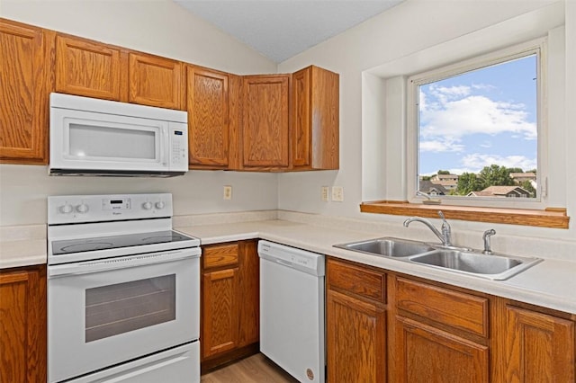 1361 Ozark Rdg, Coralville, IA 52241 - kitchen featuring white appliances, brown cabinetry, light countertops, and lofted ceiling