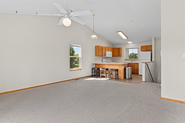 1361 Ozark Rdg, Coralville, IA 52241 - kitchen with white appliances, brown cabinetry, open floor plan, carpet, and a peninsula