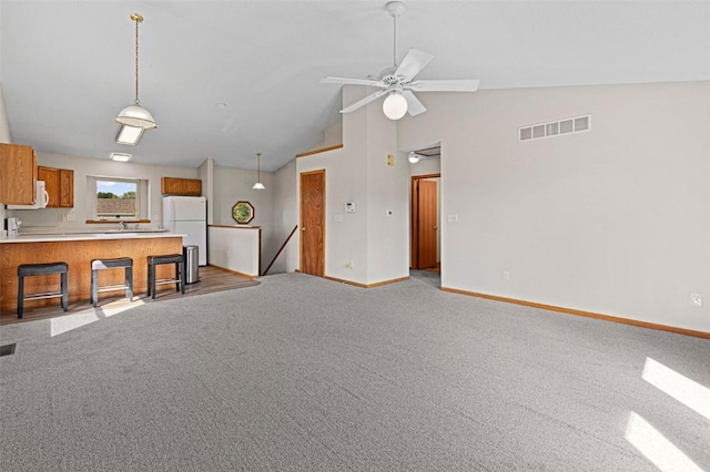 1361 Ozark Rdg, Coralville, IA 52241 - kitchen featuring freestanding refrigerator, brown cabinetry, a peninsula, light countertops, and light carpet