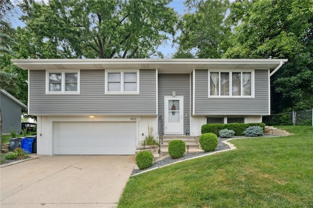 1654 19th St NW, Cedar Rapids, IA 52405 - split foyer home with concrete driveway, a garage, and brick siding