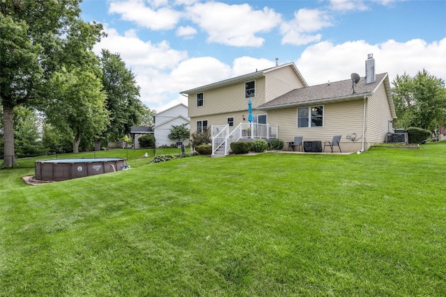 364 Essex Dr NE, Cedar Rapids, IA 52402 - back of house featuring a hot tub, a chimney, a deck, a yard, and a patio area