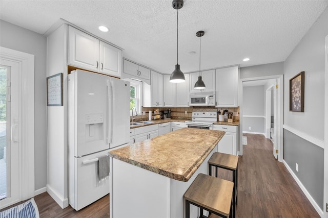 364 Essex Dr NE, Cedar Rapids, IA 52402 - kitchen featuring white appliances, white cabinets, dark wood-style flooring, a kitchen island, and a textured ceiling