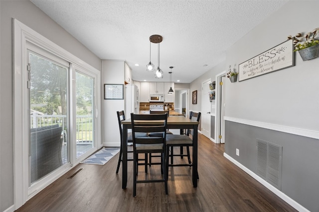 364 Essex Dr NE, Cedar Rapids, IA 52402 - dining room with dark wood-style flooring, a textured ceiling, and recessed lighting