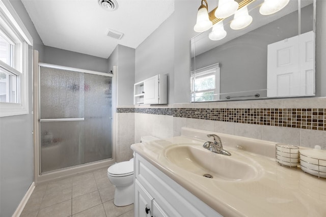 364 Essex Dr NE, Cedar Rapids, IA 52402 - bathroom featuring tile patterned flooring, vanity, a stall shower, tile walls, and wainscoting