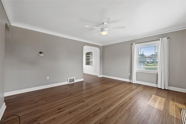 2500 D Ave NE, Cedar Rapids, IA 52402 - empty room with arched walkways, a ceiling fan, crown molding, and dark wood-style floors